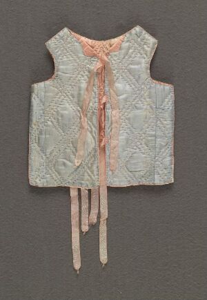  A vintage child's pale blue floral embossed bodice with pale pink satin ribbon ties against a dark gray background.