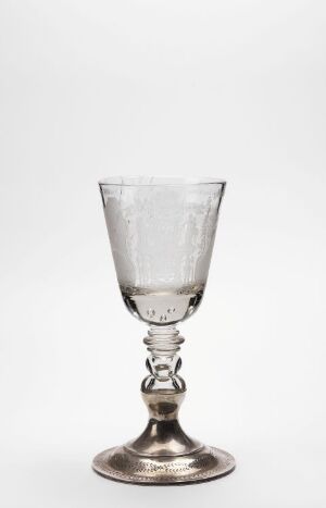  An elegant glass goblet with a clear, patterned cup and decorative metal stem on a light grey background.