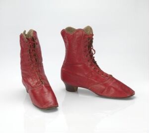  A pair of red vintage lace-up boots with minimal wear, presenting a historical and feminine design, against a white background.