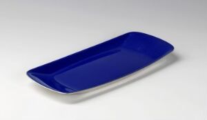  A rectangular, stainless steel serving tray with rounded edges, designed by Grete Prytz Kittelsen, featuring a glossy, cobalt blue enamel coating on its interior surface set against a plain, light-colored background.