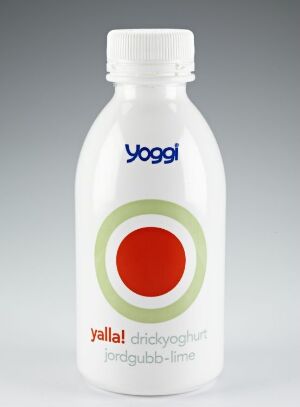  A white plastic drinkable yogurt bottle with the brand "Yoggi" in blue text at the top. It features a circular label design with concentric circles in green and red, and additional text below in blue and black, suggesting flavor or product information. The overall design is simple, modern, and suggests a strawberry-flavored yogurt beverage.