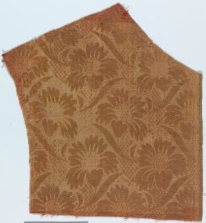  A piece of antique rusty brown fabric with an embossed floral pattern, irregularly shaped and textured, suggesting historical use and design.