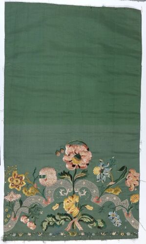  A dark green rectangular fabric featuring a decorative pattern of symmetrical flowers and vines in pastel colors, with a prominent large pink bloom at the center of the arrangement near the bottom.