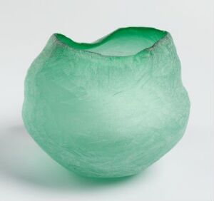  The "Anemone" by Kari Mølstad, a seafoam green blown glass piece with an uneven, organically shaped rim and textured surface suggestive of a sea anemone, set against a light neutral background.