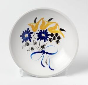  A porcelain plate designed by Randi Gulbrandsen, featuring a hand-painted enamel decoration of stylized flowers in yellow and blue tied with a blue ribbon on a white background.