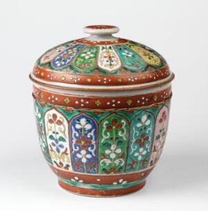  A Bencharong porcelain lidded bowl with intricate patterns in emerald green, cobalt blue, yellow, white, and pinkish red over a deep rust background. It is an example of traditional Thai design and craftsmanship in ceramics. Artist unknown.