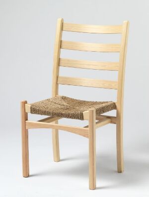  "Aksel" chair by Gerhard Berg, made of pine with a light, natural finish and a seat of woven seagrass, set against a neutral background.