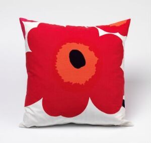  Decorative pillow with Maija Isola's "Unikko" poppy design, featuring a large red poppy with a black and orange center on a white background, with a zipper visible at the edge, exemplifying machine-woven cotton craftsmanship.