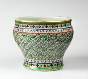  A Bencharong porcelain vessel with a flared lip and rounded base, showcasing vibrant overglaze enamel colors in a geometric and floral pattern with a gilded rim, reflective of traditional Thai ceramics. Artist name is unknown.