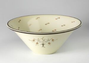  A cream-colored feldspar porcelain bowl designed by Nora Gulbrandsen featuring delicate overglaze decoration with small botanical patterns around the interior. The bowl tapers gracefully from a wide opening to a narrow base and gives off an impression of understated elegance.