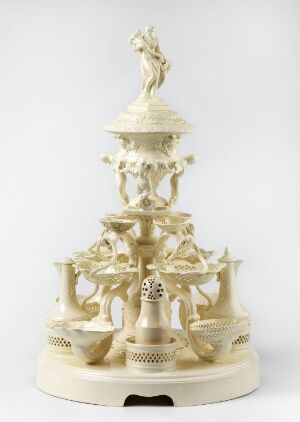  Intricate multi-tiered ivory carving on a plain background, featuring delicately carved human and animal figures with elaborate patterns, possibly a musical or automaton piece.