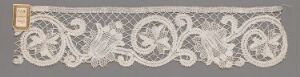  A vintage lace fragment with a pattern of intricate white swirls and floral motifs on a muted, grayish beige background, showcasing traditional lacemaking artistry. The lace has a scalloped edge and denotes a sense of elegance and fine craftsmanship. Artist name and title unknown.