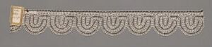  A gold-colored bracelet with ornate, interlocking scalloped shapes and a rectangular clasp on a grey background.