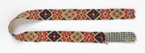  A narrow strip of intricately patterned fabric, mostly cream in color with symmetrical red, blue, and yellow diamond motifs, ending in a checkered pattern with lighter shades of blue and red. Artist name and title are unknown.