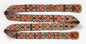  Three ornately patterned textile straps or belts with geometric designs in red, blue, and orange, finished with metallic end caps, laid out against a white background.