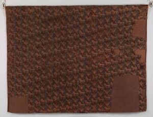  A rectangular textile art piece with a repetitive embossed pattern in warm brown shades, conveying a sense of depth and elaborate craftsmanship. Artist's name and title are unknown.