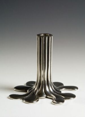  A pewter light fixture by Svenskt Tenn, featuring a base that spreads out in rounded, flat shapes with an elongated cylindrical column arising from the center, set against a gradient background shading from white to dark gray.