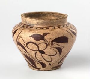  A ceramic pot with a bulbous body and a narrow top, featuring warm beige tones and adorned with symmetrical dark brown or black floral patterns. The pot's rim is also darker, providing a contrast with the lighter body.