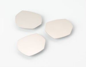  Three polished steel objects by Ilkka Suppanen, titled "Stones," with a matte, light grey finish imitating natural pebbles, arranged against a clean white gradient background.