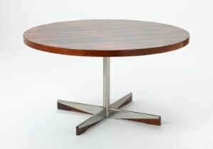  "Planet" table, a mid-century modern design piece by Sven Ivar Dysthe, with a circular palisander (rosewood) veneered top and a star-shaped steel base on a white background reflecting a harmonious blend of nature and industrial elegance.