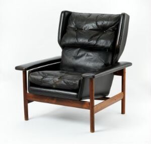  A Sven Ivar Dysthe-designed armchair with a rosewood frame and black leather cushions, showcasing mid-century modern luxury with a lauded combination of comfort and style.