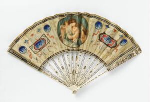  A vintage hand fan with a central romantic vignette and surrounding blue and gold decorative elements on a cream-colored background with intricate metallic ribs.