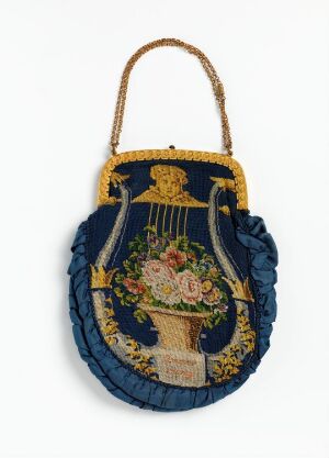  An antique oval-shaped bag with deep blue fabric and decorative gold lyre and colorful flower embroidery in the center, a gold beaded handle, and pleated blue trim.