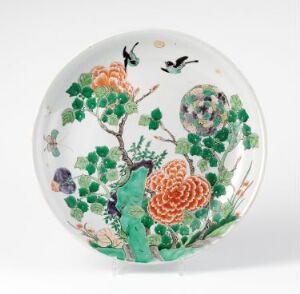  A detailed and colorful porcelain plate featuring a vibrant floral and bird design with a white background, showcasing a striking contrast between the flowers, birds, and foliage.