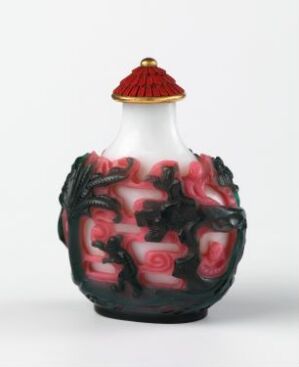  A bulbous, marbled glass vase with swirling patterns of rose and white, featuring black dragon-like relief decorations around its middle, and capped with a ridged coral red lid. The vase exudes a blend of traditional elegance and contemporary artistry.