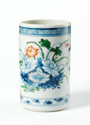  A white porcelain cylindrical vase with intricate blue and white floral patterns and a geometric border around the rim.