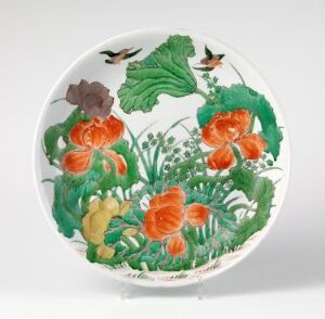  Decorative plate featuring a hand-painted design of orange poppies with green foliage and small insects set against a white background. The plate is displayed on a stand, underscoring its ornamental purpose.