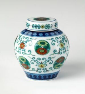  A small, ornate, white glazed porcelain vase with a bulbous body, narrow neck, and flared rim, featuring intricate patterns in cobalt blue, green, red, and yellow with Eastern artistic influences.