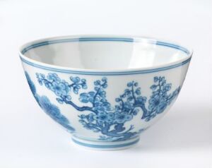  A traditional blue and white porcelain bowl with intricate floral designs, set against a light grey background.