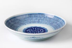  A shallow, circular porcelain bowl with intricate cobalt blue patterns on a white background, placed against a plain light-colored surface. Artist and title are unknown.