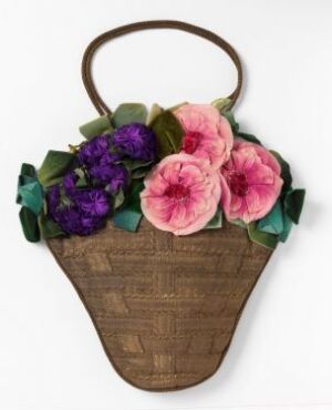  A conical wicker basket with an arched handle, adorned with a mix of large pink and smaller purple flowers, interspersed with various shades of green leaves.