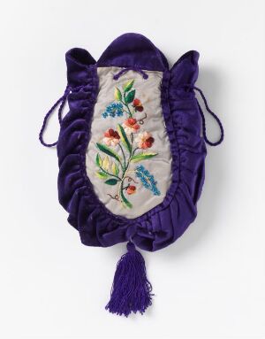  An antique royal purple velvety handbag with central embroidery featuring red, orange, and yellow flowers on a creamy white background, secured with drawstrings and embellished with a purple tassel at the bottom.