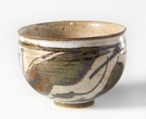  A handmade ceramic bowl with an irregular rim, featuring earthy beige tones and abstract swirls in brown, black, and faded white on the exterior.