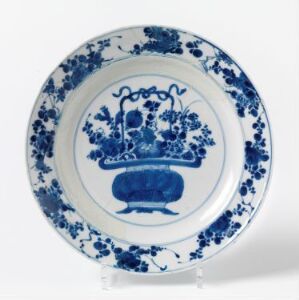  A circular white ceramic plate with traditional blue floral and vase patterns in the style of Delft or Chinese blue and white porcelain.