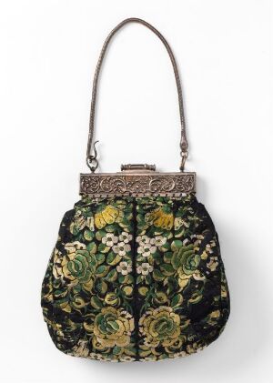  An intricately designed handbag with dense, embroidered floral patterns in shades of yellow, white, and orange on a dark green background, featuring an ornate metal frame with a clasp and a graceful curved handle.