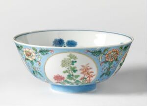  A porcelain bowl with a bright sky-blue exterior and detailed multi-colored floral patterns. The bowl has a white interior with a small decorative border along the edge.