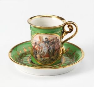  A porcelain tea cup and saucer set with emerald green glaze and gold trim. The cup has a painted scene of classical figures on the side, and the saucer has a matching design.