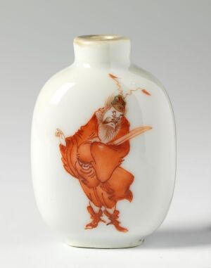  A porcelain vase with a white glaze featuring an orange-red painted figure of a traditional East Asian male character, depicted with a dynamic pose and expressive facial features, against a pristine white background.