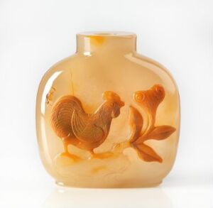  An intricately carved amber-colored snuff bottle with a raised relief of a cockerel on the front, set against a plain white background.