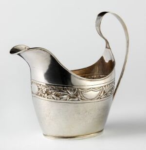  A polished silver pitcher with an ornamental band and graceful handle stands against a neutral background, showcasing its shiny surface and golden interior reflection. Artist name and title are unknown.