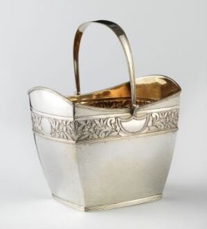  A small silver-colored metal bucket with a decorative embossed band featuring foliage motifs, a polished handle, and a contrasting gold-toned interior. Artist name and title remain unknown.