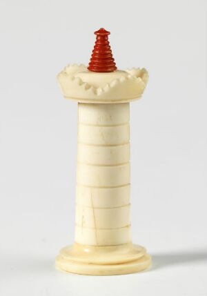  Ivory-colored chess rook with a vivid red conical top set against a light gray background. The rook has a grooved cylindrical base with a battlement-style crown, suggesting the sturdy architecture of a castle.