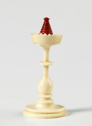  A white chess queen piece with distinctive red spikes on its crown stands against a light grey background, with a soft shadow cast to the right.