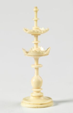  An intricately carved white king chess piece with elaborate designs and a cross on top, set against a light-grey background.