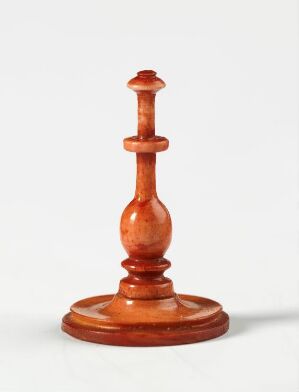  A wooden chess King piece with a warm, polished finish standing against a simple light background.