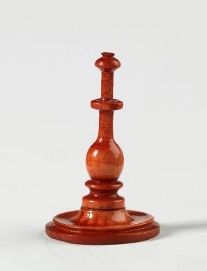  A reddish-brown wooden king chess piece stands against a neutral background, showcasing the polished craftsmanship and the classic design details of the piece.